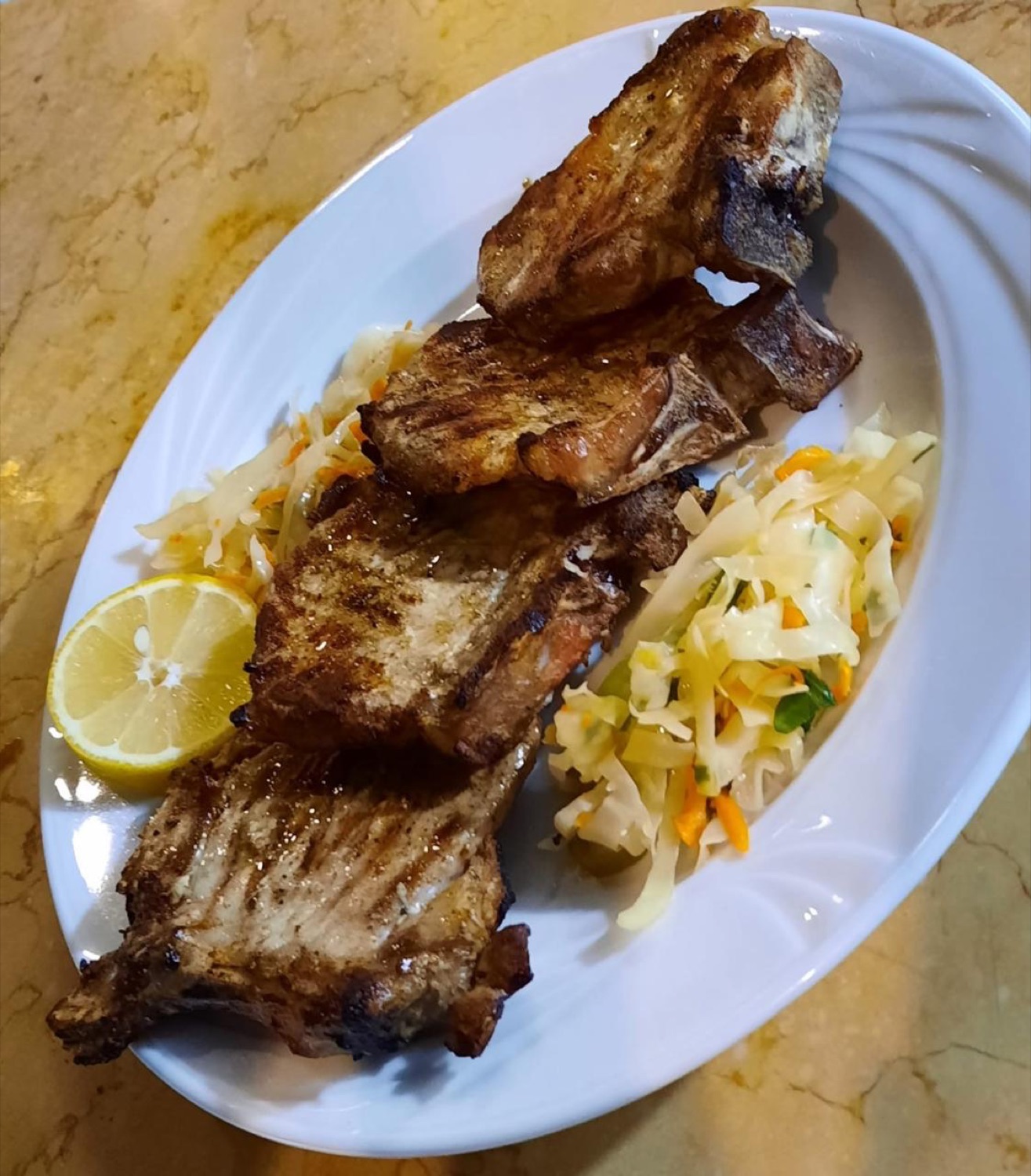 Grilled ribs with cabbage slaw and lemon